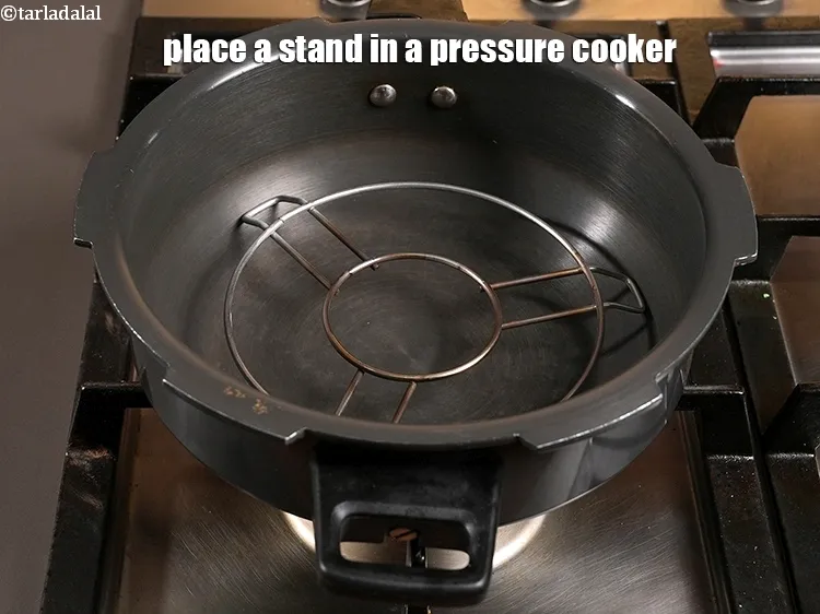 Step 3 – <p>Place a stand in a pressure cooker.</p>