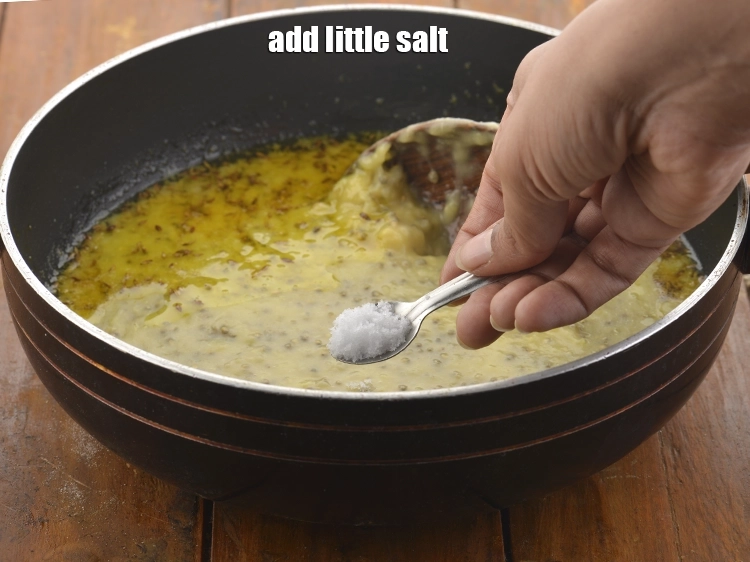 Step 21 – <p><span style="background-color:rgb(255,255,255);color:rgb(0,0,0);">Add little salt to </span><strong>Bajra and Moong Dal Khichdi.</strong></p>