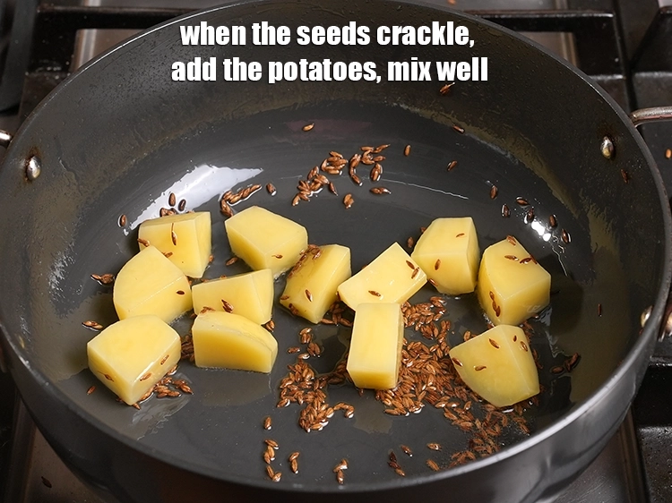 Step 12 – <p><span style="background-color:rgb(255,255,255);color:rgb(0,0,0);">When the seeds crackle, add the 1/2 cup raw </span><a href="https://www.tarladalal.com/glossary-potatoes-aloo-alu-batata-710i#ing_2328"><u>potato cubes</u></a><span style="background-color:rgb(255,255,255);color:rgb(0,0,0);">. Mix …
