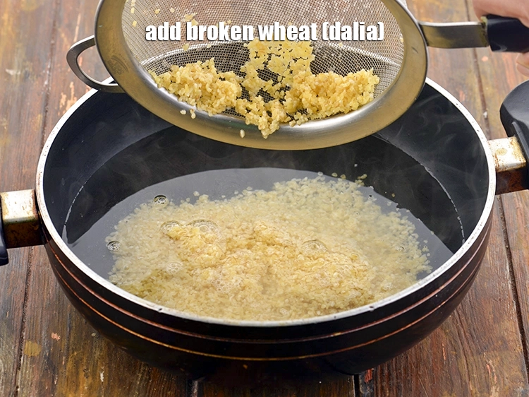 Step 5 – <p><span style="background-color:rgb(255,255,255);color:rgb(0,0,0);">Add the </span><a href="https://www.tarladalal.com/glossary-broken-wheat-dalia-bulgur-wheat-lapsi-fada-426i"><u>broken wheat (dalia)</u></a><span style="background-color:rgb(255,255,255);color:rgb(0,0,0);"> to it</span></p>