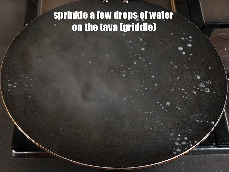 Step 11 – <p>Sprinkle a few drops of water on the tava (griddle).</p>