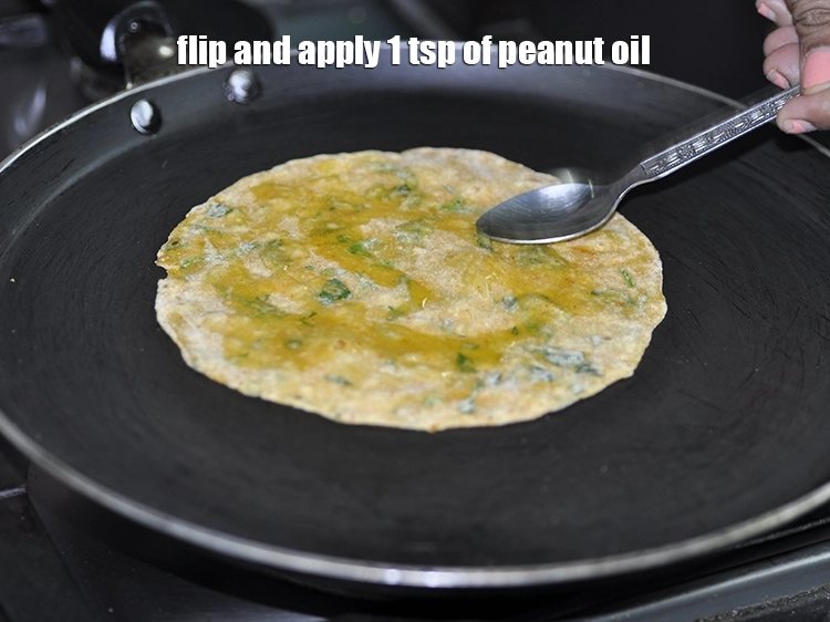 Step 18 – <p>Flip and apply 1 tsp of <a href="https://www.tarladalal.com/glossary-peanut-oil-groundnut-oil-sing-tel-920i"><u>peanut oil</u></a> around the <strong>methi thepla</strong>.</p>