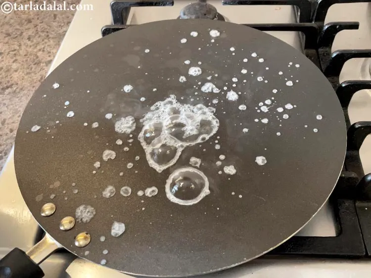 Step 25 – <p>To prepare<strong> adai dosa</strong>, heat a non-stick tava (griddle) and sprinkle a little water on …