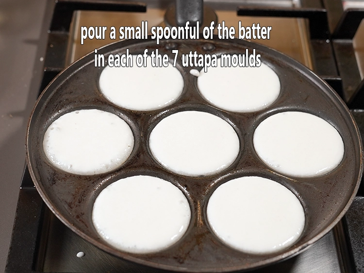 Step 5 – <p>Pour a small spoonful of the batter in each of the 7 uttapa moulds. We …