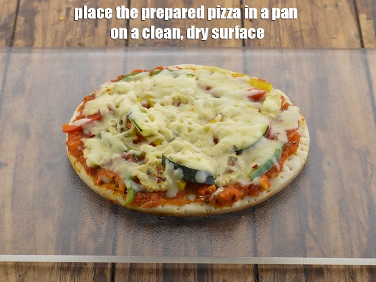 Step 34 – <p>Place the prepared <strong>pizza in a pan</strong>&nbsp;on a clean, dry surface.</p>