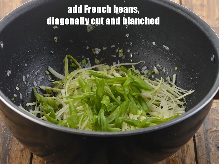 Step 21 – <p><span style="background-color:rgb(255,255,255);color:rgb(0,0,0);">Now, add the 1/4 cup </span><a href="https://www.tarladalal.com/glossary-French-beans-fansi-196i#ing_2655"><u>diagonally cut and blanched French beans</u></a><u>.</u></p>