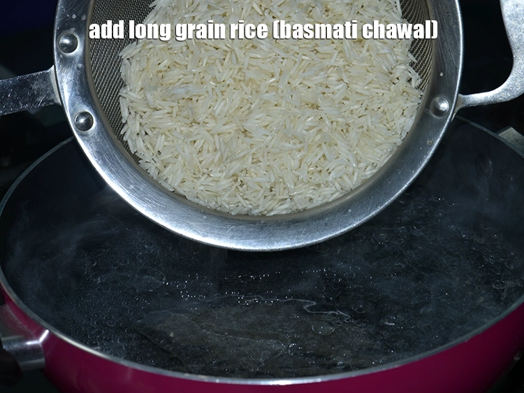 Step 7 – <p>Add the <a href="https://www.tarladalal.com/glossary-long-grain-rice-basmati-chawal-basmati-rice-535i"><u>long grain rice (basmati chawal)</u></a> to the boiling water and mix well.</p>