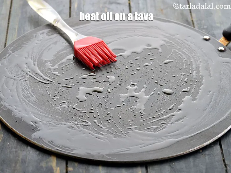 Step 43 – <p>For cooking the <strong>patties</strong>, heat 1 tbsp oil on a tava (griddle).</p>