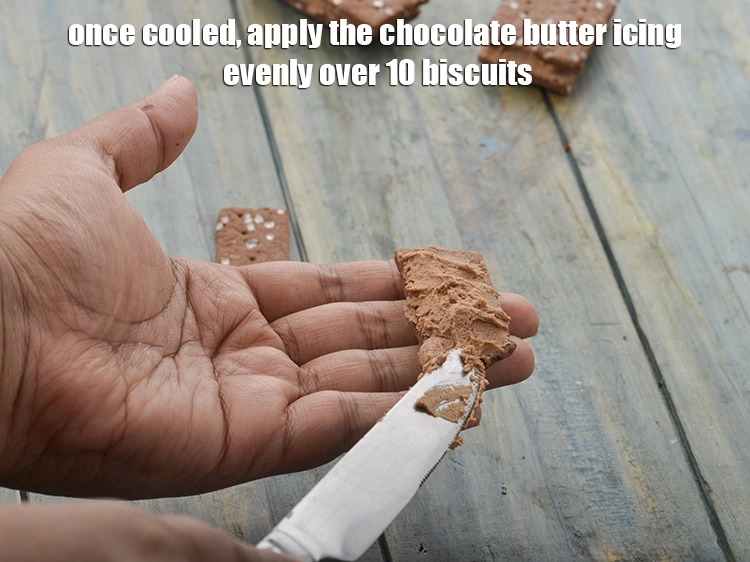 Step 8 – <p><span style="background-color:rgb(255,255,255);color:rgb(0,0,0);">Once cooled, apply the chocolate butter icing evenly over 10 biscuits.</span></p>