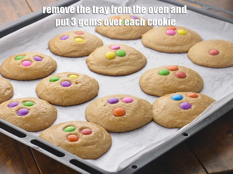 Step 7 – <p>Remove the tray from the oven and put 3 <a href="https://www.tarladalal.com/glossary-gems-625i"><u>gems</u></a> over each cookie.</p>