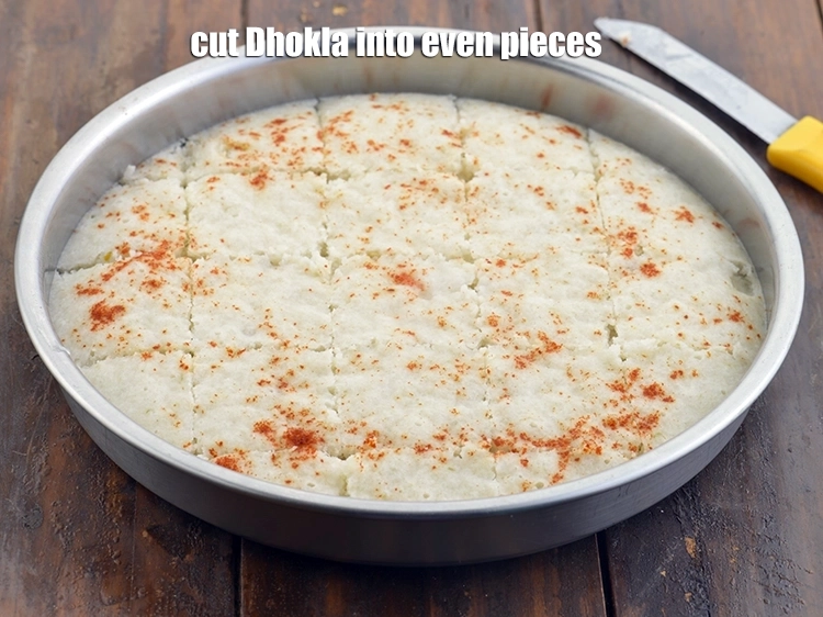 Step 9 – <p><span style="background-color:rgb(255,255,255);color:rgb(0,0,0);">Cut&nbsp;</span><strong>Khatta Dhokla</strong><span style="background-color:rgb(255,255,255);color:rgb(0,0,0);">&nbsp;into even pieces.</span></p>