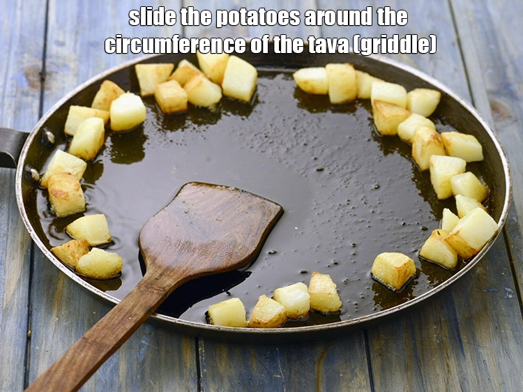 Step 2 – <p><span style="background-color:rgb(255,255,255);color:rgb(0,0,0);">Slide the potatoes around the circumference of the tava (griddle).</span></p>