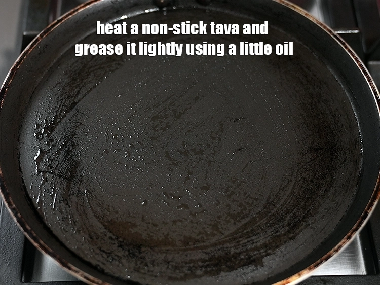 Step 11 – <p><span style="background-color:rgb(255,255,255);color:rgb(0,0,0);">Heat a non-stick tava and grease it lightly using a little </span><a href="https://www.tarladalal.com/glossary-oil-671i"><u>oil</u></a><span style="background-color:rgb(255,255,255);color:rgb(0,0,0);">.</span></p>