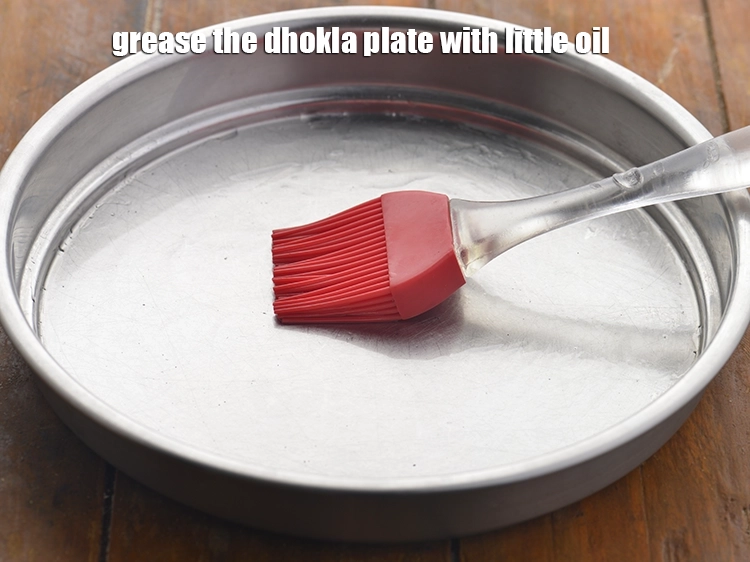 Step 15 – <p>For steaming the <strong>no-fermentation</strong> <strong>moong dal dhokla</strong>, grease the dhokla plate with little oil and …