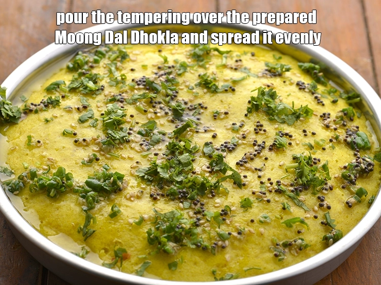 Step 25 – <p><span style="background-color:rgb(255,255,255);color:rgb(0,0,0);">Pour the tempering over the prepared&nbsp;</span><strong>Moong Dal Dhokla</strong><span style="background-color:rgb(255,255,255);color:rgb(0,0,0);">&nbsp;and spread it evenly. Sprinkle the …