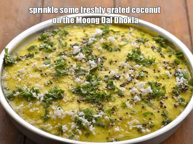 Step 26 – <p><span style="background-color:rgb(255,255,255);color:rgb(0,0,0);">Also, sprinkle some freshly 1 tbsp </span><a href="https://www.tarladalal.com/glossary-coconut-nariyal-269i#ing_3229"><u>grated coconut</u></a><span style="background-color:rgb(255,255,255);color:rgb(0,0,0);"> on the&nbsp;</span><strong>Moong Dal Dhokla.</strong></p>
