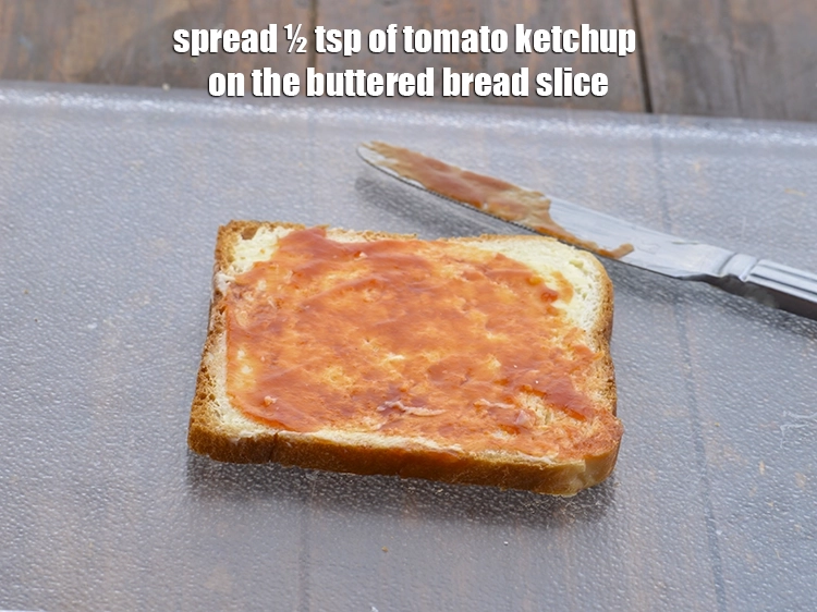 Step 10 – <p><span style="background-color:rgb(255,255,255);color:rgb(0,0,0);">Spread ½ tsp of </span><a href="https://www.tarladalal.com/glossary-tomato-ketchup-tomato-sauce-181i"><u>tomato ketchup</u></a><span style="background-color:rgb(255,255,255);color:rgb(0,0,0);"> on the buttered bread slice.</span></p>