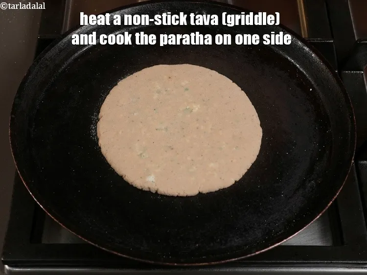 Step 24 – <p>Heat a non-stick tava (griddle) and cook the paratha on one side. Place the paratha …