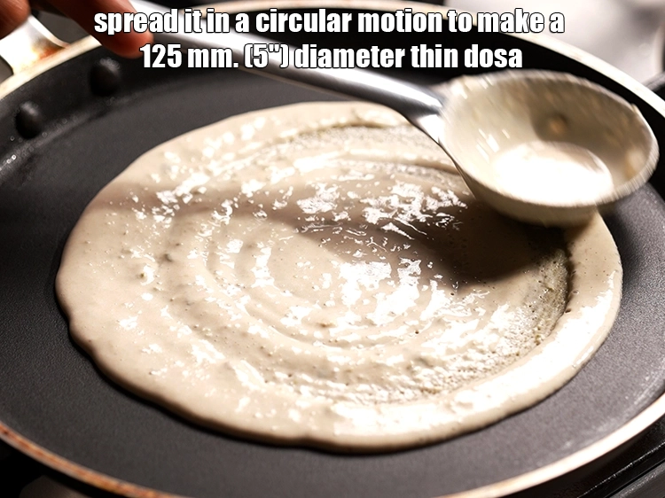 Step 13 – <p>Spread it in a circular motion to make a 125 mm. (5") diameter thin dosa. …