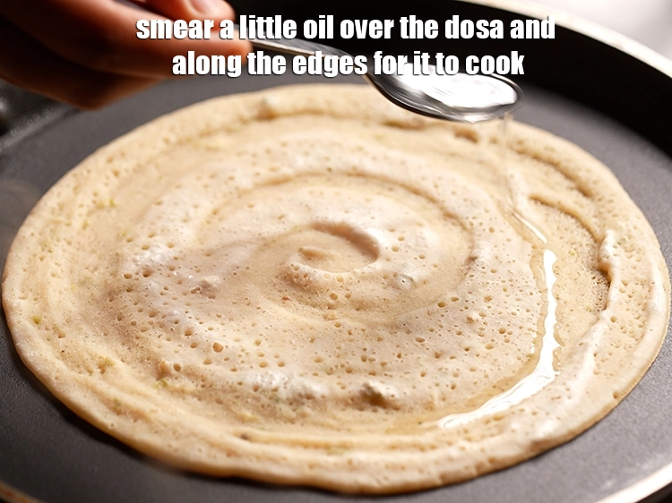 Step 14 – <p>Smear a little <a href="https://www.tarladalal.com/glossary-oil-671i"><u>oil</u></a> over the dosa and along the edges for it to …