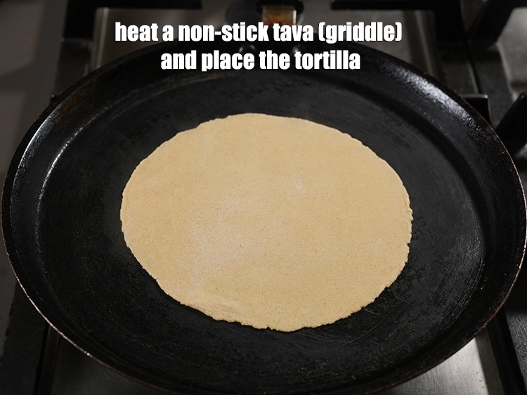 Step 11 – <p><span style="background-color:rgb(255,255,255);color:rgb(0,0,0);">Heat a non-stick tava (griddle). place the tortilla gently over it.</span></p>