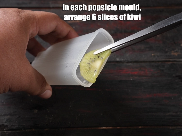 Step 7 – <p><span style="background-color:rgb(255,255,255);color:rgb(0,0,0);">In each popsicle mould, arrange 6 slices of </span><a href="https://www.tarladalal.com/glossary-kiwi-767i#ing_3008"><u>kiwi slices </u></a><span style="background-color:rgb(255,255,255);color:rgb(0,0,0);">, cut …