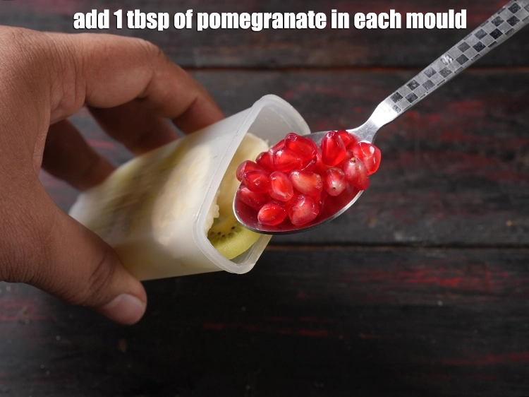 Step 9 – <p>Add 1 tbsp of <a href="https://www.tarladalal.com/glossary-pomegranate-seeds-anar-dana-anardana-seeds-588i"><u>pomegranate seeds (anardana)</u></a> in each mould.</p>
