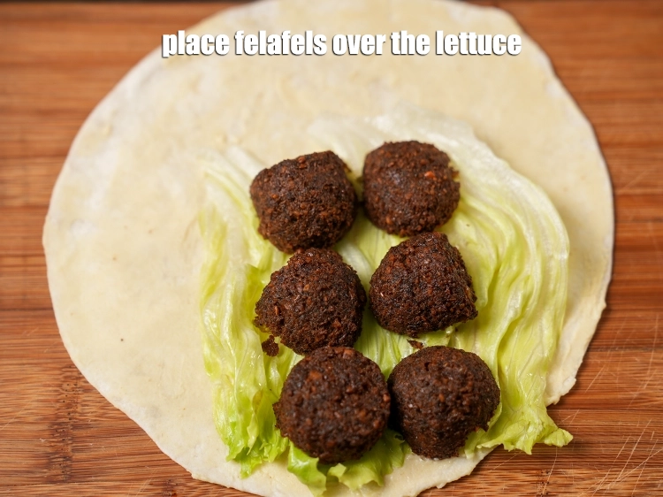Step 29 – <p><span style="background-color:rgb(255,255,255);color:rgb(0,0,0);">Place the <strong>felafels </strong>over the lettuce.</span></p>