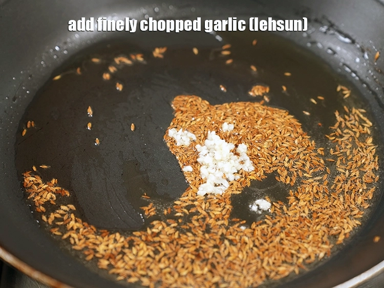 Step 23 – <p><span style="background-color:rgb(255,255,255);color:rgb(0,0,0);">When the seeds crackle, add 1/2 tsp finely </span><a href="https://www.tarladalal.com/glossary-garlic-lehsun-lahsun-348i#ing_2370"><u>chopped garlic (lehsun)</u></a><u>.</u></p>
