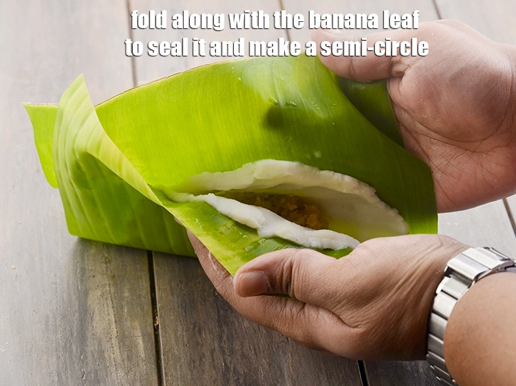 Step 12 – <p><span style="color:rgb(13,13,13);">Fold along with the banana leaf to seal it and make a semi-circle.</span></p>