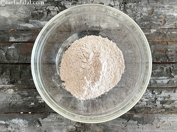 Step 11 – <html><head></head><body><p>In a deep bowl put&nbsp;1/2 cup&nbsp;<a href="glossary-ragi-nachni-red-millet-finger-millet-596i">ragi (nachni / red millet)</a>&nbsp;flour.</p></body></html>