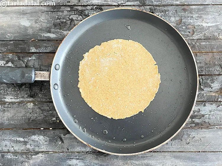 Step 28 – <html><head><meta charset="UTF-8"> </head><body><p>Place the rolled out&nbsp;<strong>Khakhra</strong>&nbsp;dough on the greased tava.</p></body></html>