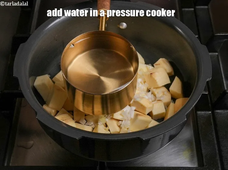 Step 5 – <p>Add 2 cups of water in a pressure cooker.</p>