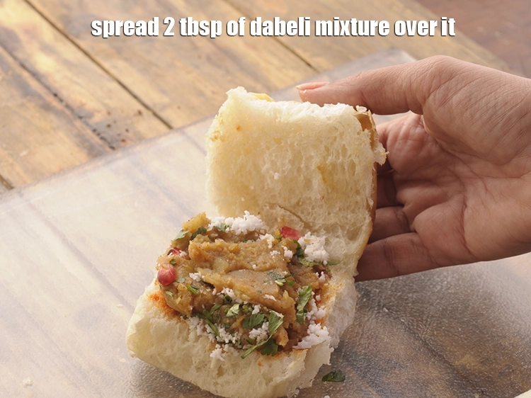 Step 20 – <p>Then spread 2 tbsp of <strong>dabeli mixture</strong> over it.&nbsp;Press it with the back of a …