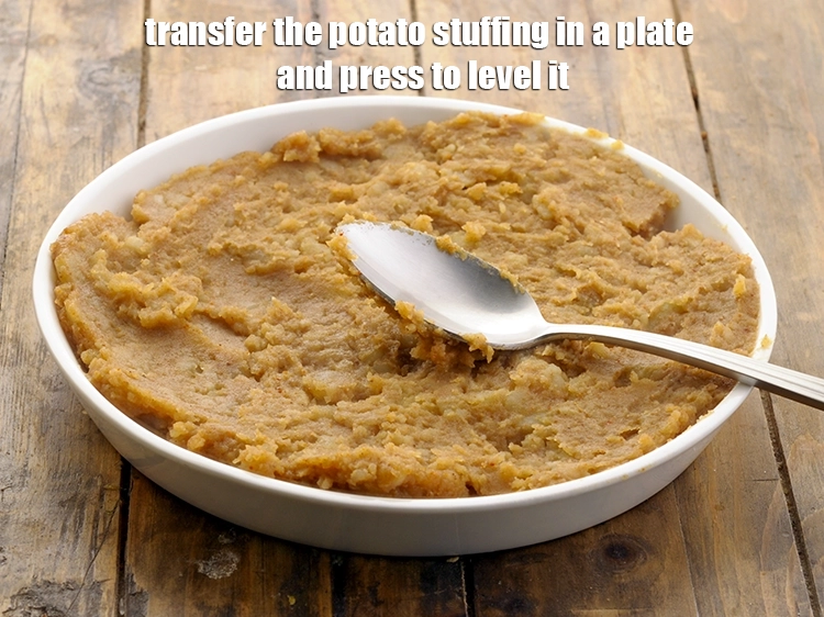 Step 13 – <p>Transfer the <strong>potato stuffing</strong> in a plate and press to level it.</p>