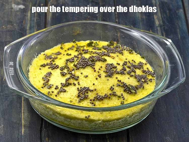 Step 8 – <p><span style="background-color:rgb(255,255,255);color:rgb(0,0,0);">Pour the tempering over the <strong>dhoklas</strong>.</span></p>