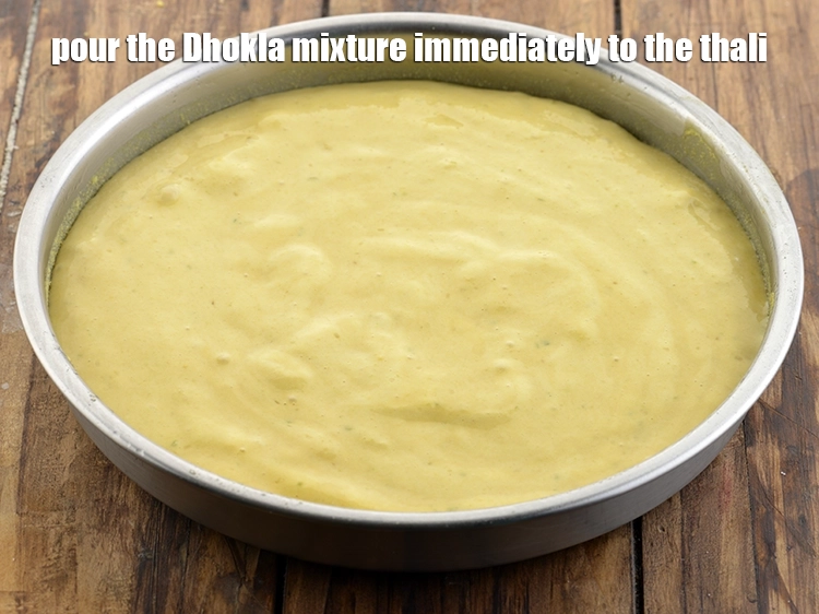 Step 13 – <p>Pour the <strong>Nylon Khaman Dhokla </strong>mixture immediately to the thali.</p>