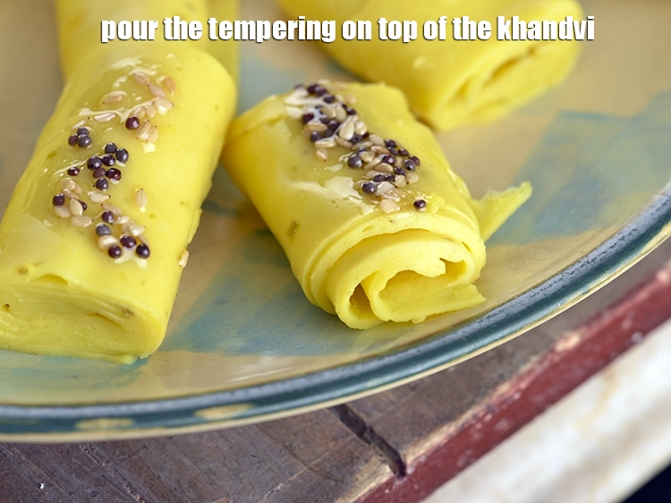Step 6 – <p><span style="background-color:rgb(255,255,255);color:rgb(0,0,0);">Pour the tempering on top of the <strong>khandvi</strong>.</span></p>