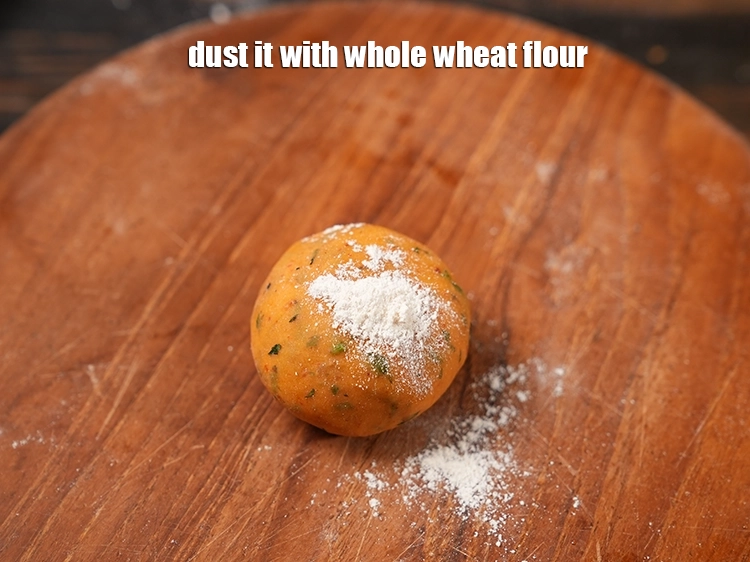 Step 24 – <p>Flatten it and <span style="background-color:rgb(255,255,255);color:rgb(0,0,0);">Dust it with </span><a href="https://www.tarladalal.com/glossary-whole-wheat-flour-gehun-ka-atta-gehun-ka-aata-429i"><u>whole wheat flour (gehun ka atta)</u></a><span style="background-color:rgb(255,255,255);color:rgb(0,0,0);">.</span></p>