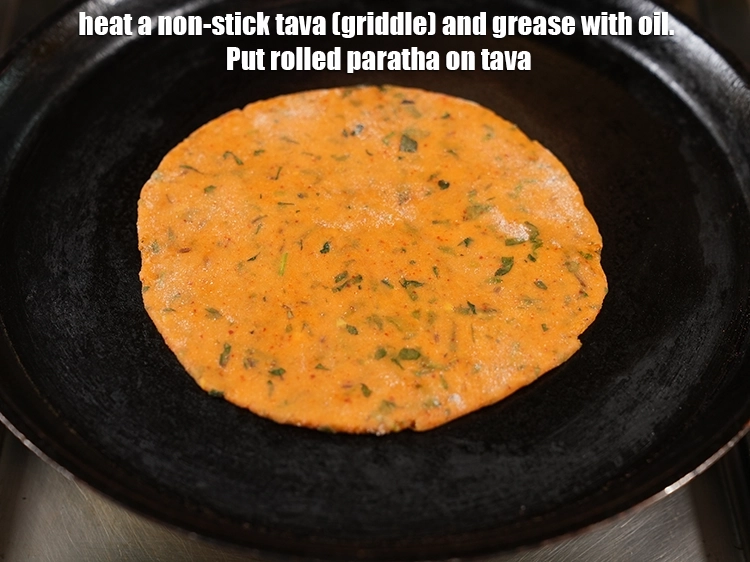 Step 26 – <html><head><meta charset="UTF-8"></head><body><p>Heat a non-stick tava (griddle) and grease with <a href="https://www.tarladalal.com/glossary-oil-671i"><u>oil</u></a>. Put rolled <strong>paratha</strong> on …