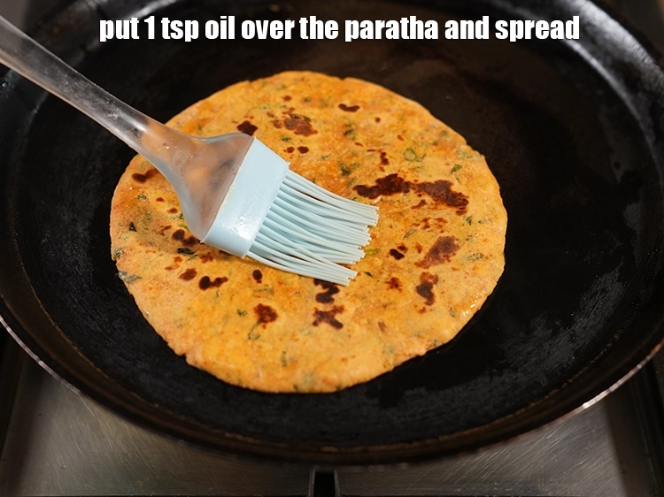 Step 29 – <p>Put 1 tsp <a href="https://www.tarladalal.com/glossary-oil-671i"><u>oil</u></a> over the<strong> paratha</strong> and spread with spatula.</p>