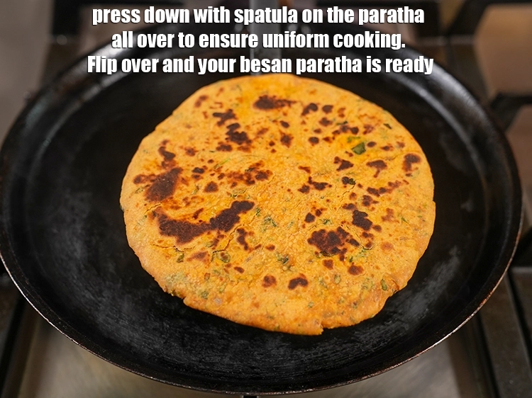 Step 30 – <p>Press down with spatula on the <strong>paratha</strong> all over to ensure uniform cooking. Flip over …