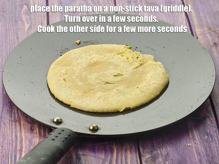 Step 51 – <p>Place the paratha on a non-stick tava (griddle). Turn over in a few seconds. Cook …