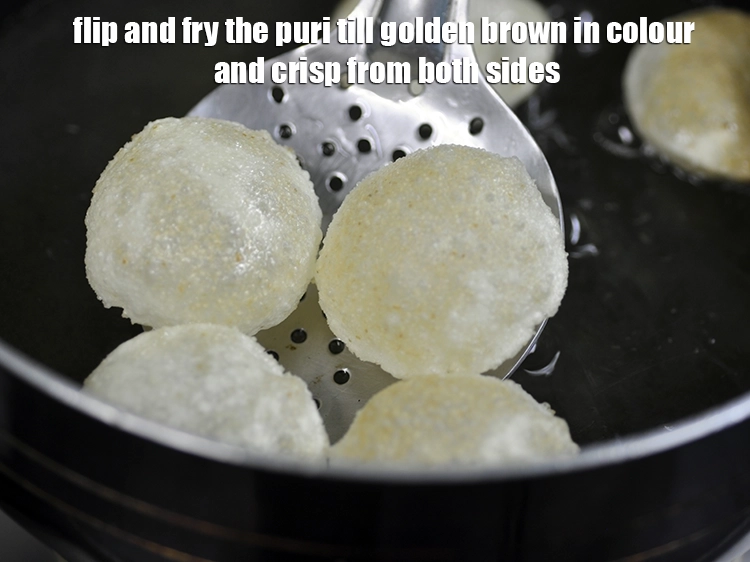 Step 14 – <p>Flip and fry the puri till golden brown in colour and crisp from both sides.</p>