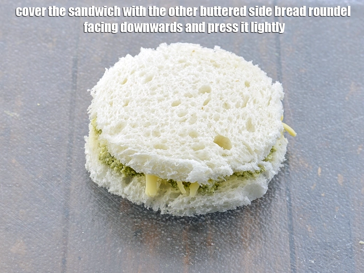 Step 6 – <p><span style="background-color:rgb(255,255,255);color:rgb(0,0,0);">Cover the <strong>sandwich</strong> with the other buttered side bread roundel facing downwards and press …