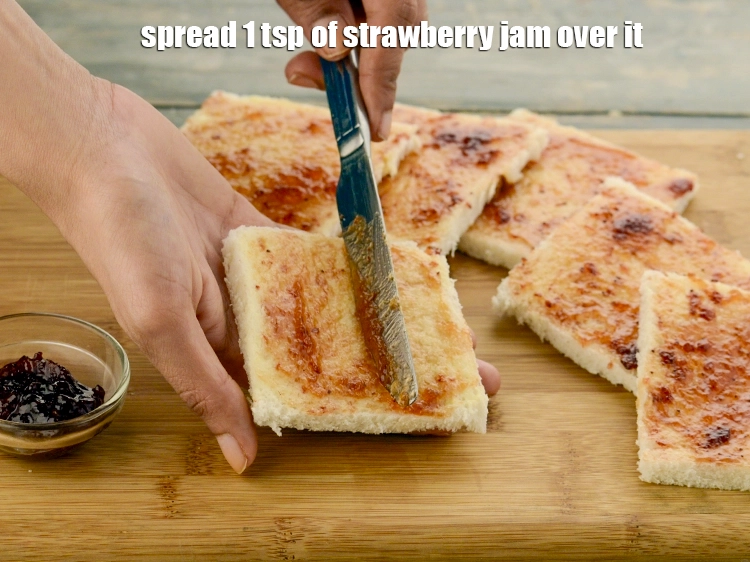 Step 19 – <p>Spread 1 tsp&nbsp;of <a href="https://www.tarladalal.com/strawberry-jam-fresh-strawberry-jam-recipe-2555r">strawberry jam</a>&nbsp;over it. Remember you have to roll it up, so …