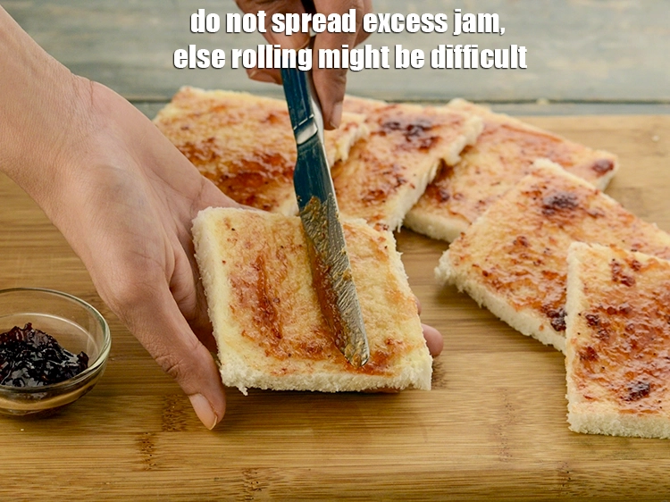 Step 26 – <p><span style="background-color:rgb(255,255,255);color:rgb(0,0,0);">Do not spread excess </span><a href="https://www.tarladalal.com/glossary-strawberry-jam-243i"><strong><u>strawberry jam</u></strong></a><span style="background-color:rgb(255,255,255);color:rgb(0,0,0);">, else rolling might be difficult.</span></p>