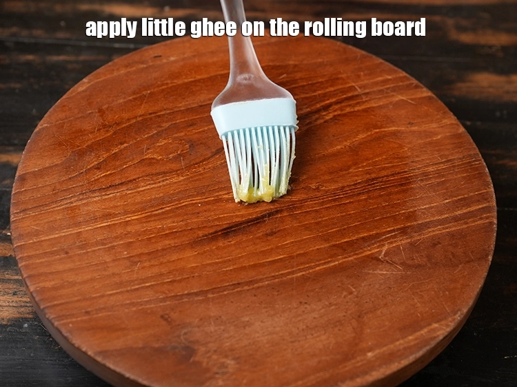 Step 26 – <p><span style="background-color:rgb(255,255,255);color:rgb(0,0,0);">Apply little </span><a href="https://www.tarladalal.com/glossary-ghee-245i"><u>ghee</u></a><span style="background-color:rgb(255,255,255);color:rgb(0,0,0);"> on the rolling board.</span></p>