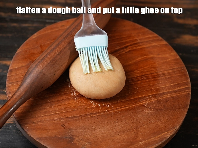 Step 18 – <p>Flatten a <strong>dough</strong> ball and put a little <a href="https://www.tarladalal.com/glossary-ghee-245i"><u>ghee</u></a> on top.</p>