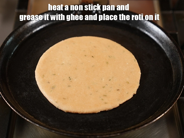 Step 20 – <p>Heat a non stick pan and grease it with <a href="https://www.tarladalal.com/glossary-ghee-245i"><u>ghee</u></a>. Place the <strong>roti </strong>on …